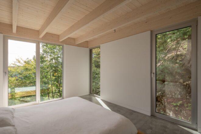 large white bed in white room with large windows