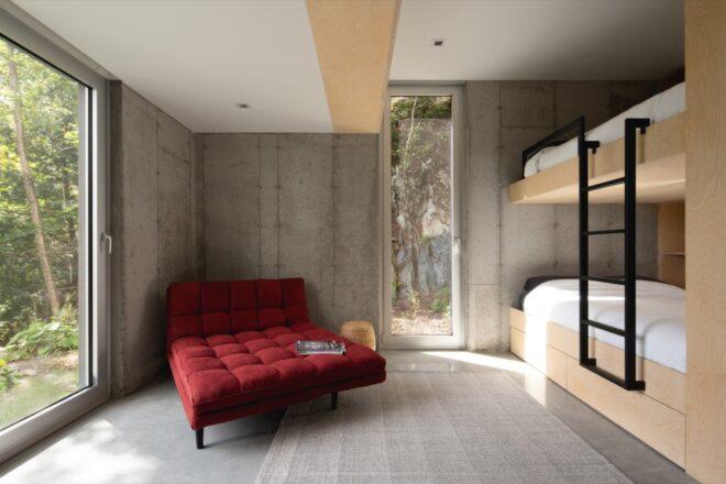 red chaise across from wood bunk beds