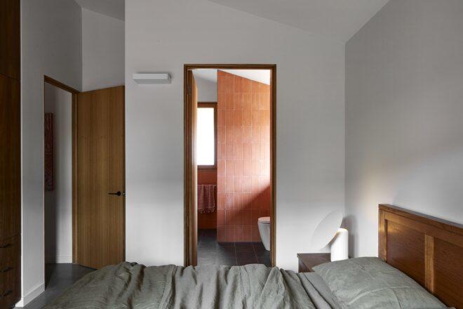 gray bed with wood headboard in white room