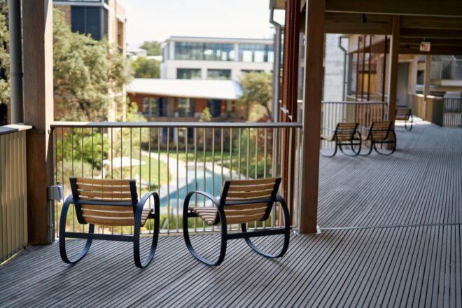 two wood chairs facing hotel pool