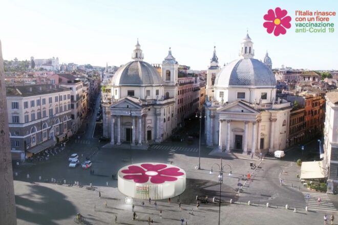 rendering of white building with pink flower logo on roof in public square