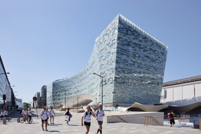people walking outside large office building with pixelated glass exterior