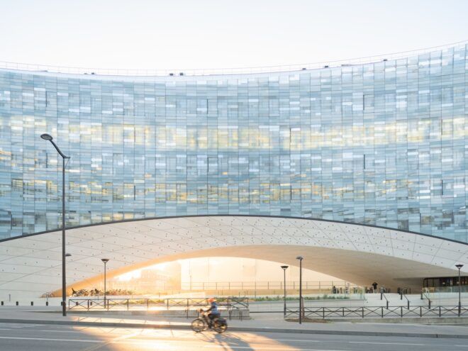person biking past glass building