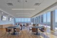 tables in white room with wood floors and glass walls