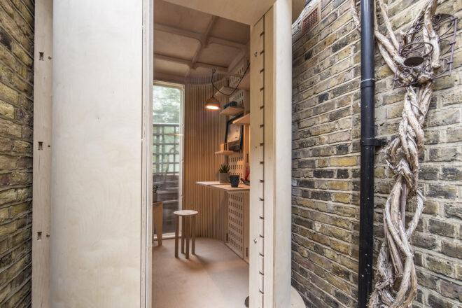 The entrance to a modular pod room in a stone alleyway.