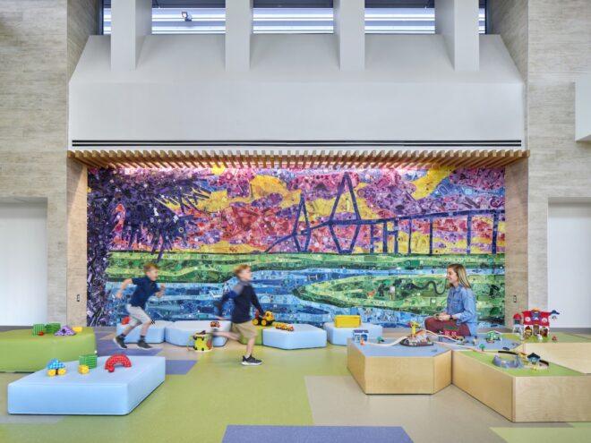 play area with blue plush seats and a colorful wall mural