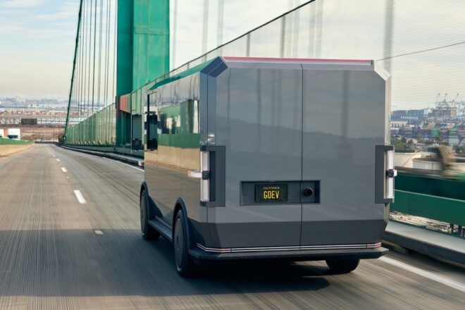 gray electric van driving across a bridge