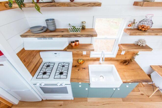 tiny house kitchen with gray cabinets and wood counters plus a full-size oven
