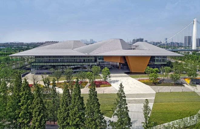 glass building with geometric gray roof