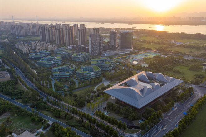 aerial view of large glass building near water at sunset