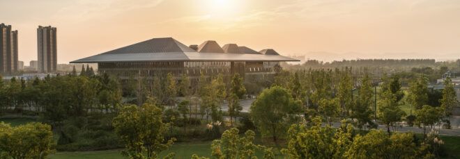 glass building with geometric gray roof at sunset