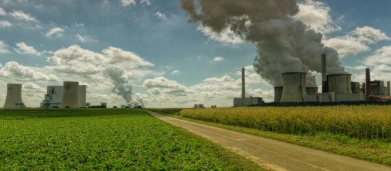 factory polluting air near a large farm