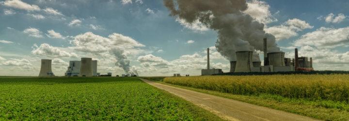 factory polluting air near a large farm