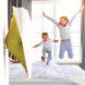 yellow bird-shaped air monitor on wall with kids jumping on bed in background