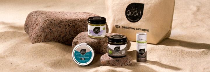 skincare products in glass and tin jars on a sandy beach
