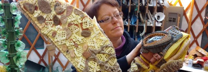 A person working on an art sculpture of a turtle.