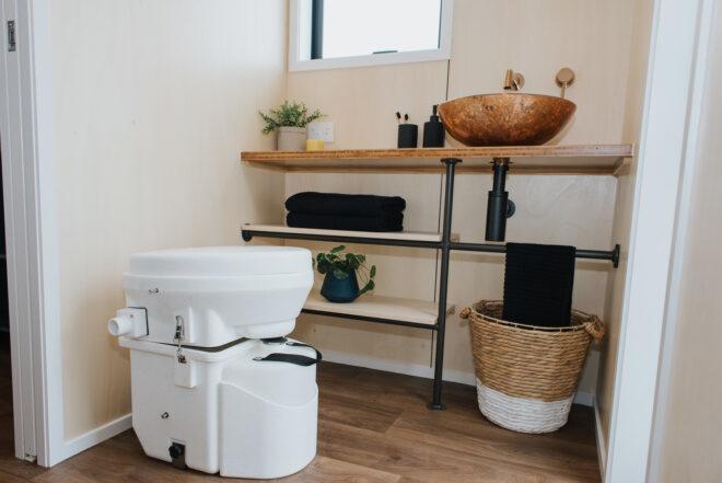 composting toilet near wood and metal shelves