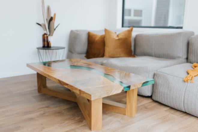 live edge and resin wood table in front of gray sofa