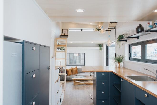 black tiny home kitchen across from gray sofa
