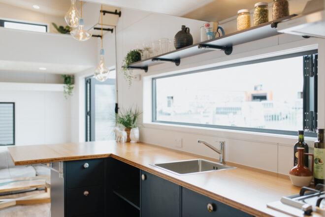 black tiny home kitchen with wood counters