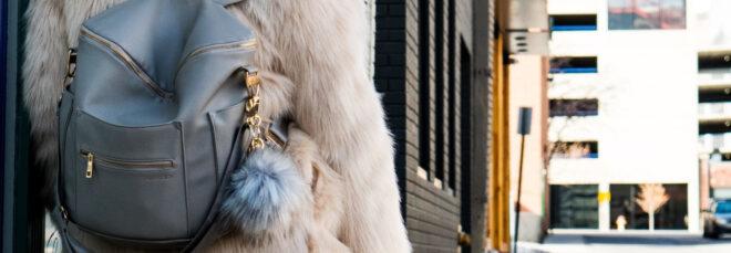 person wearing fur coat and backpack with fur keychain