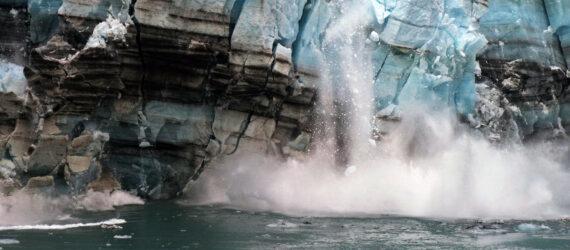 melting ice from a glacier falling into ocean