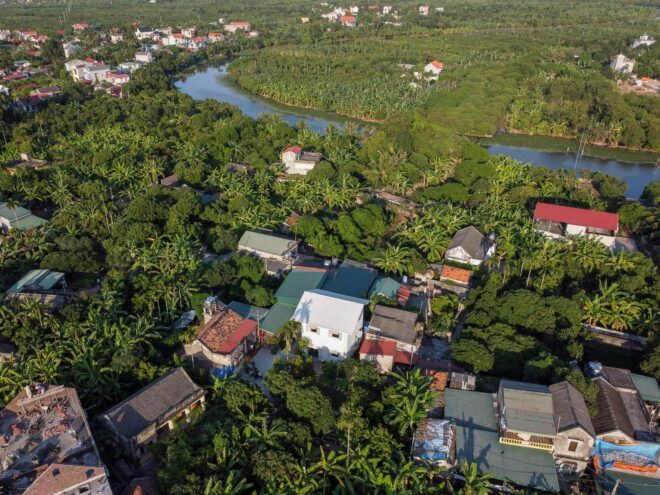 aerial view of tall white home near red homes