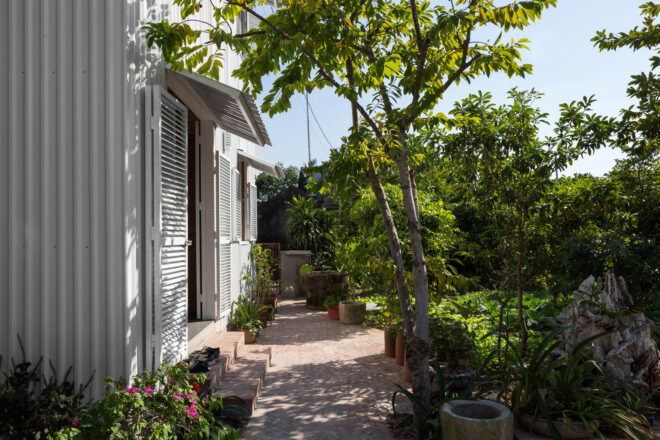 tree-lined path to a white home