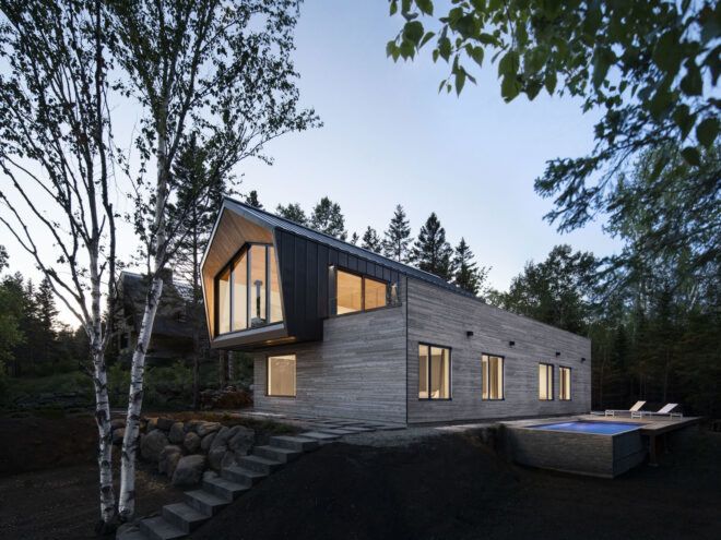 gray and black home lit from within at dusk