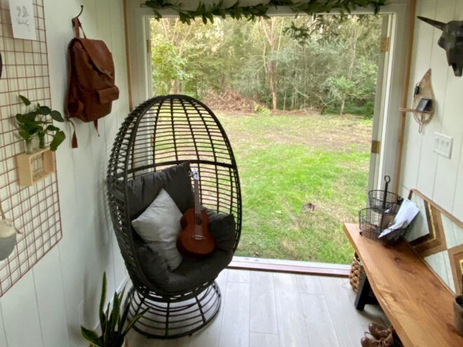 round wicker chair near wall open to outdoors