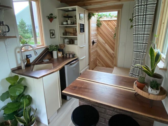 tiny kitchen with wood counters and white cabinets