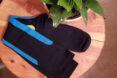 black, blue and yellow compression socks on wood table near plant