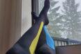 person wearing compression socks with feet resting against window