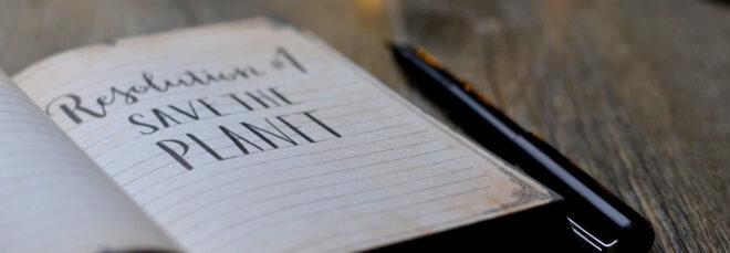 open notebook that reads, "Resolution #1: Save the Planet"