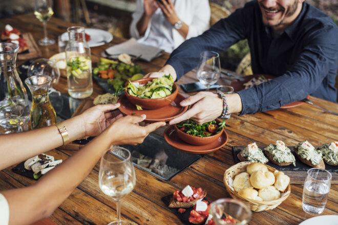 people passing salad at the table