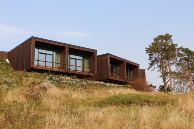 timber buildings with large windows on a hill