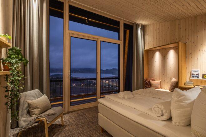 bed facing wall of glass at dusk