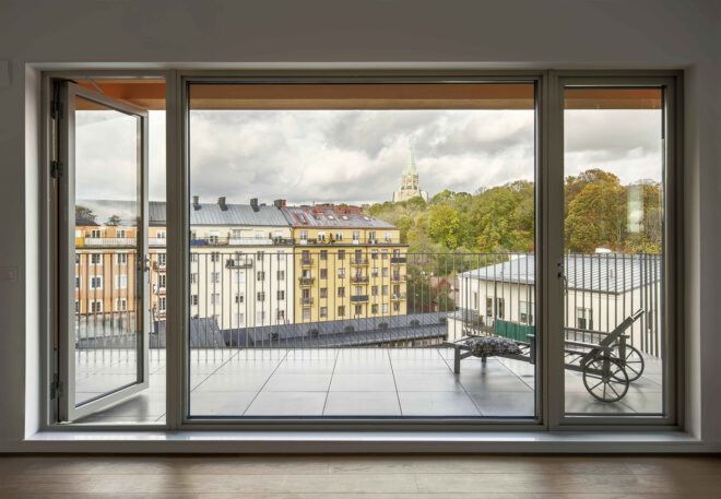 A large window with yellow curtains, looking out onto a cityscape.