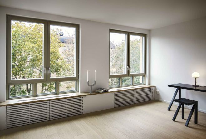 A living room area with white walls and large windows.