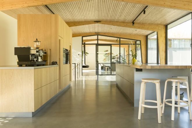 Light-colored wood cabinets in a kitchen with an island and stools.