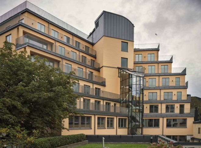 A tiered building with a green courtyard below.