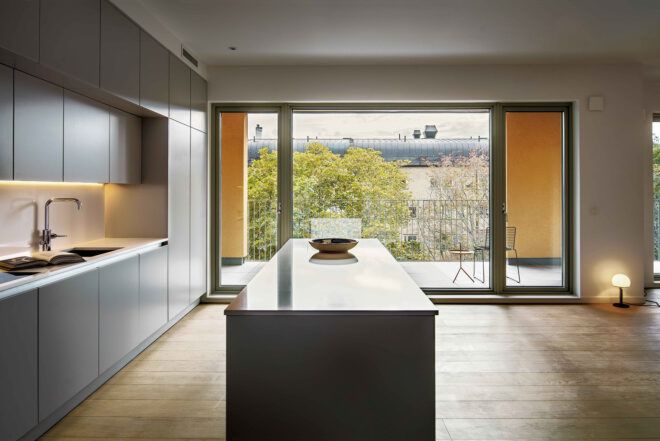 A sideview of the kitchen, showing a large window with yellow curtains in the background.