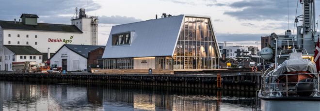 glass building with metal roof by the harbor