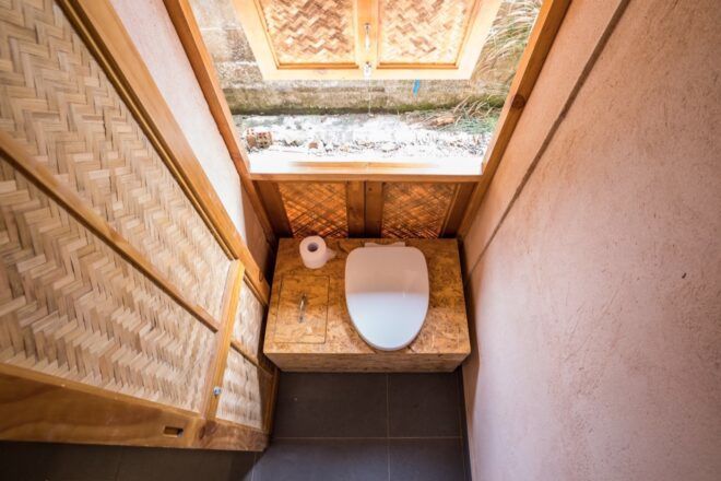 A small bathroom with natural materials and a window.