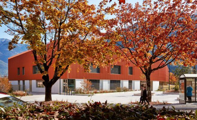 orange trees in front of bronze and concrete building