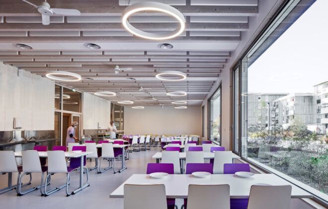 long white tables with purple chairs in room with wood ceilings and glass walls