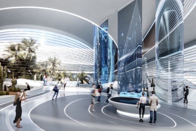 The inside of a futuristic blue, white and silver building where people linger around a desk.