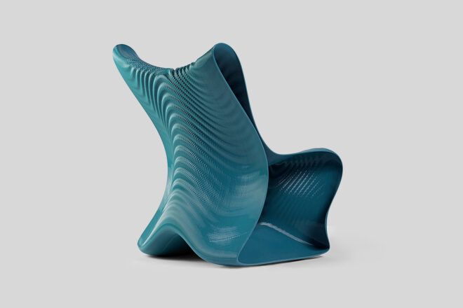 A right-back view of a dark turquoise 3D-printed chair with a wavy design and texture.