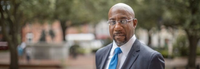 Raphael Warnock standing outside