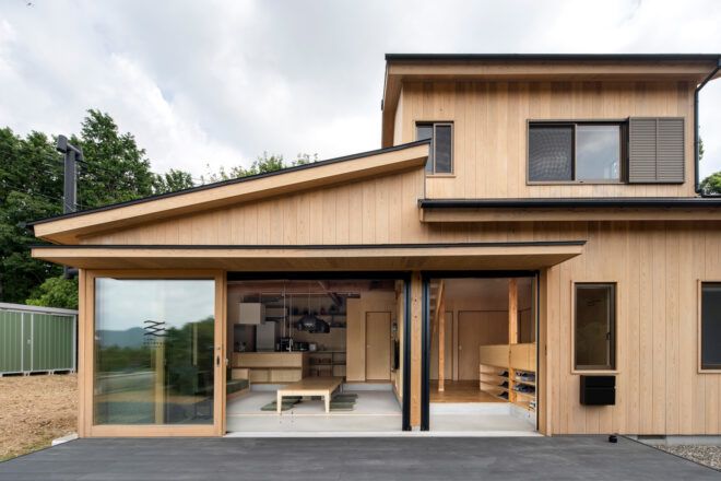cedar building with glass wall open to outdoor patio